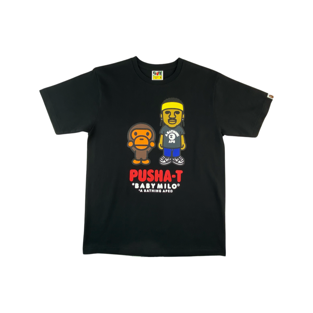A Bathing Ape Tee " Bape x Pusha T Baby Milo" -blackDas Pusha-T Tee von A Bathing Ape. Details: Großer Print mit Pusha T und Baby Milo auf der Front Gewebtes Logo am linken Arm Kurzarm, Rundhalsausschnitt schwarz mit buntem Print Passform: regular Material: 100% Baumwolle