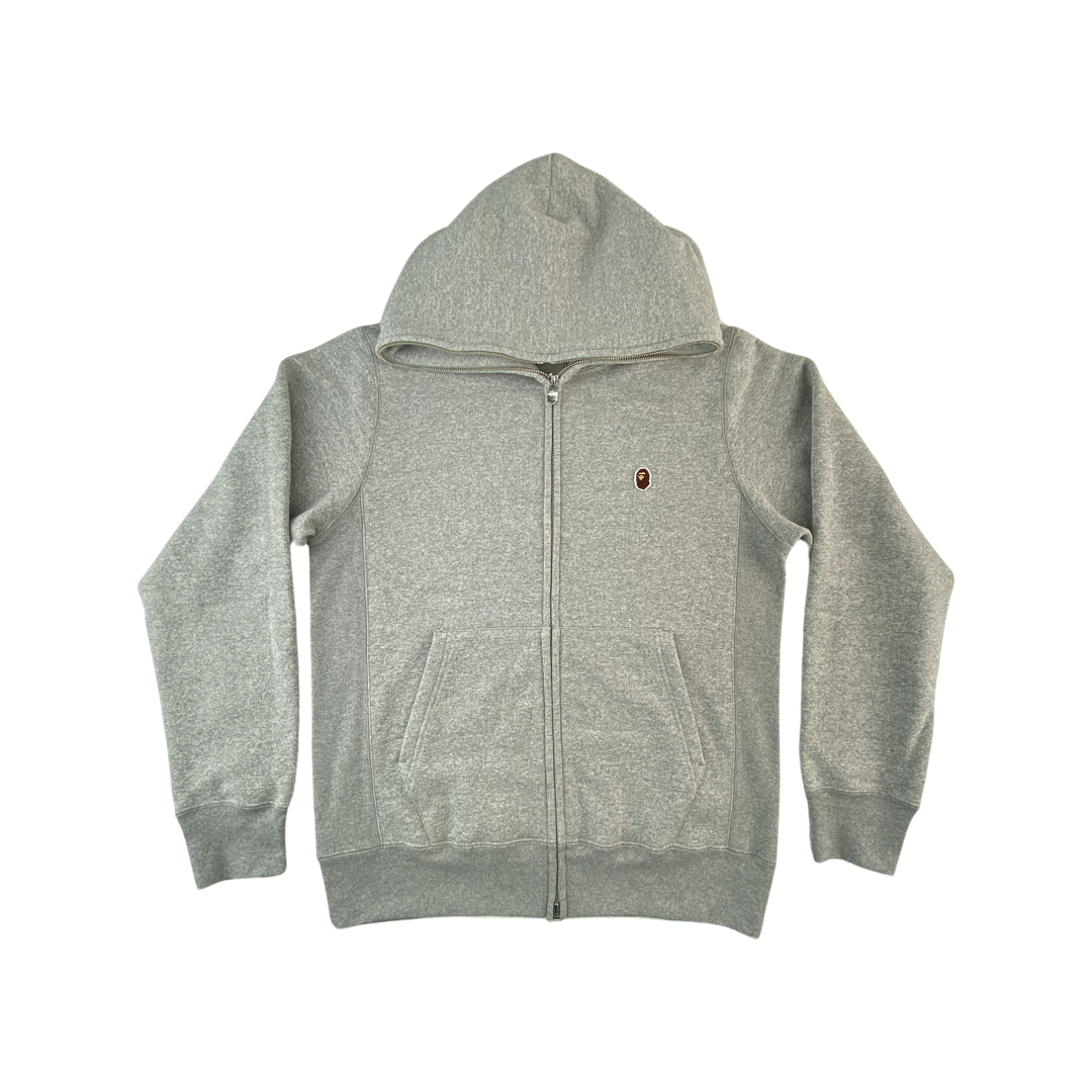 A Bathing Ape Hoodie "Ape Head One Point Relaxed Fit Full Zip Hoodie" -greyHoodie mit Reißverschluss von A Bathing Ape, der legendäre Full-Zip der bis in die Spitze der Kapuze geht Details: A Bathing Ape Logo: Ape Head Gesticktes Patch Langarm, Rundhalsausschnitt mit Kapuze grau Passform: loose fit Material: 75% Baumwolle, 25% Polyester