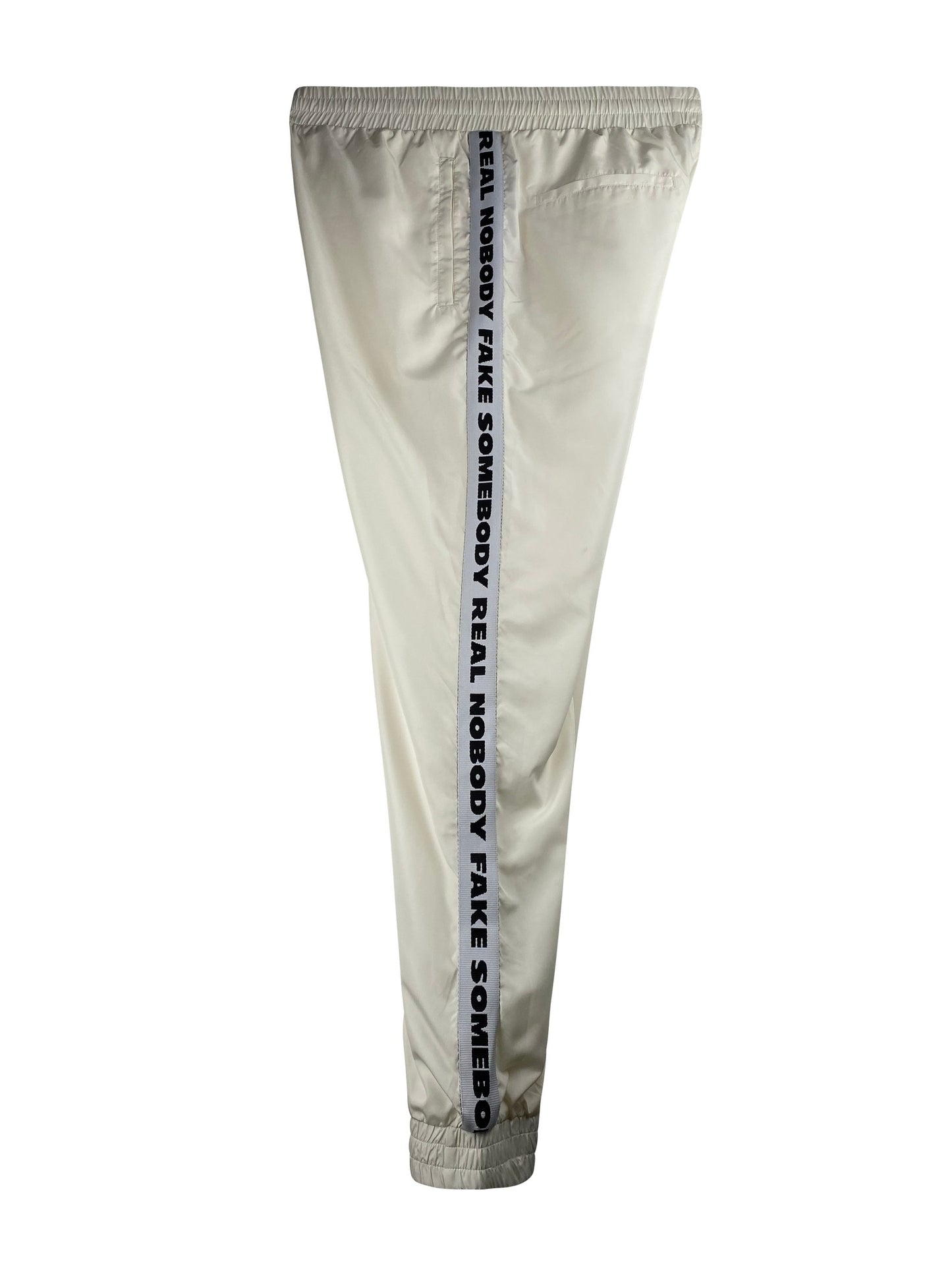 Wood Wood Hose "Robby Trousers" -off whiteEdle, weiche, pflegeleichte Joggerpant von Wood Wood. Details: Lange Hose mit breiten, weichen durchgesteppten Gummi-Bündchen-Abschluss an Beinen und Bund. Ganze Hose mit weichem Meshfutter gefüttert. Vorne seitl. Leisteneingriffstaschen mit Reißverschluss, hinten 2 Leistentaschen. Seitl. Galonband mit "Nobody Fake Somebody Real Nobody Fake Somebody....." Passform: regular fit Material: 100% Polyester, Meshfutter: 100% Polyester